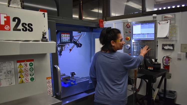 young woman at manufacturing equipment