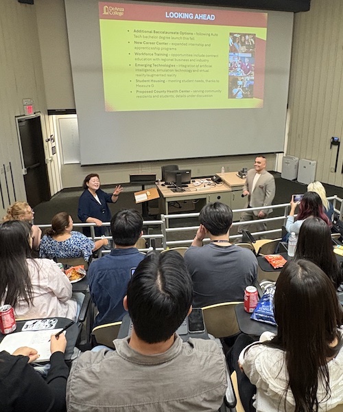 President Torres speaking in front of screen showing slide presentation