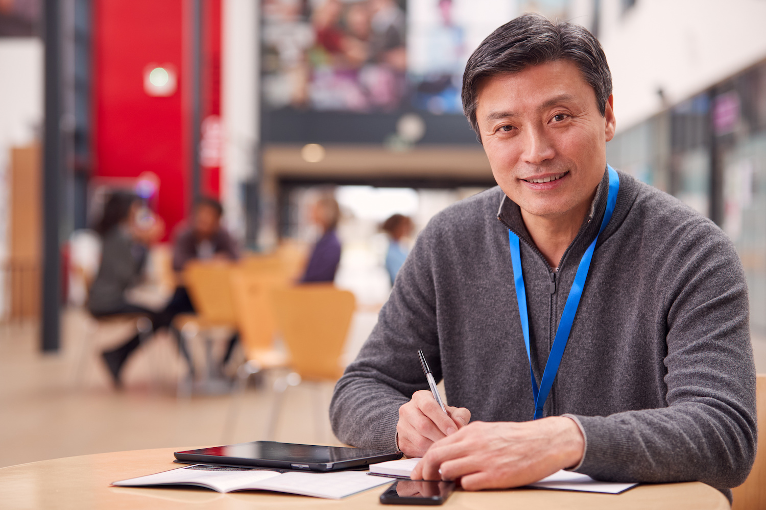 middle-aged man in sweater at desk in library