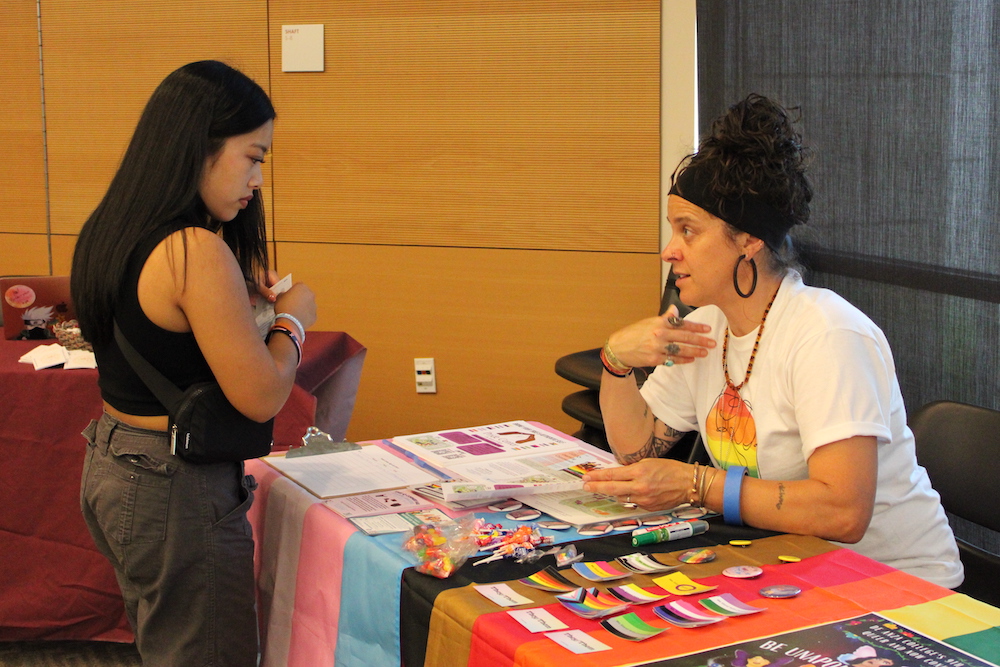 student talking with faculty member at info table