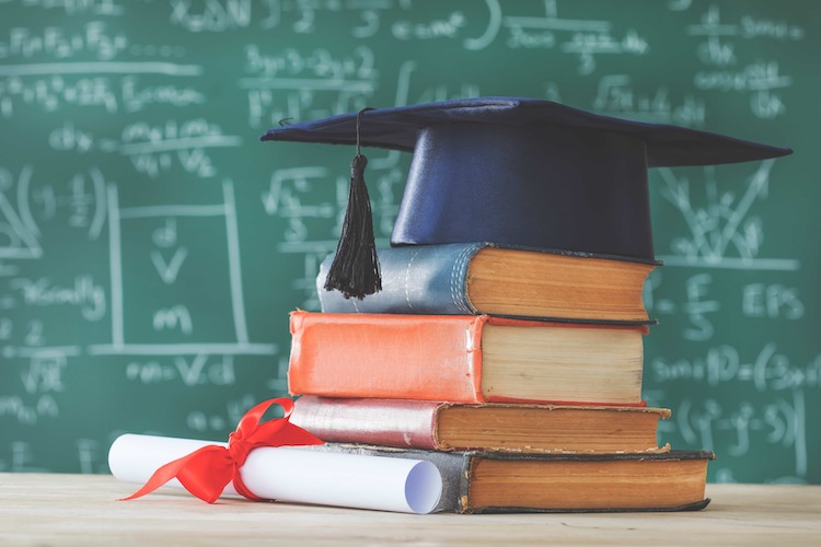 stack of books and graduation cap